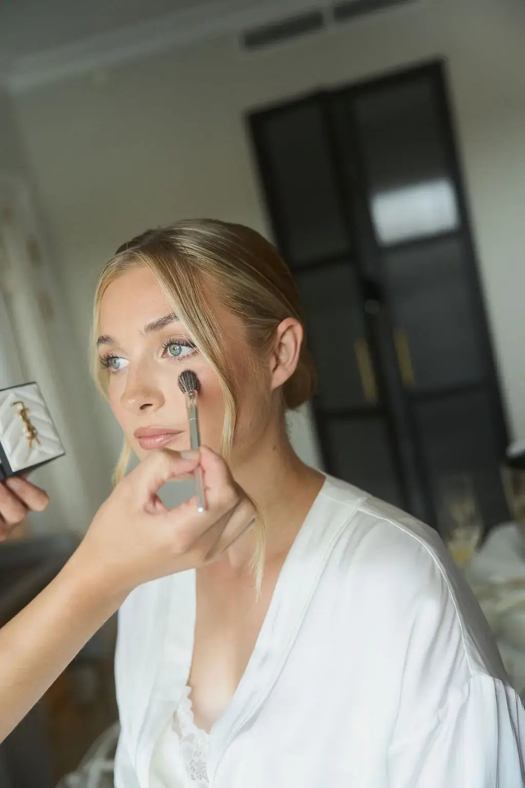 Bröllopsfotograf dokumenterar bröllopssminkning och förberedelser